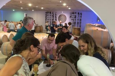 Miniature Location salle Moulis-en-Médoc (Gironde) - Château Maucaillou #8 Salle à manger élégante avec table dressée, bouquet de fleurs au centre, grande fenêtre ouverte sur un jardin verdoyant.