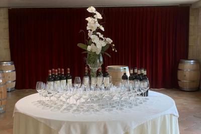 Miniature Location salle Moulis-en-Médoc (Gironde) - Château Maucaillou #4 Salle à manger élégante avec table dressée, bouquet de fleurs au centre, grande fenêtre ouverte sur un jardin verdoyant.