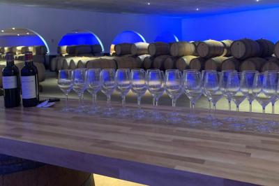 Miniature Location salle Moulis-en-Médoc (Gironde) - Château Maucaillou #5 Salle à manger élégante avec table dressée, bouquet de fleurs au centre, grande fenêtre ouverte sur un jardin verdoyant.