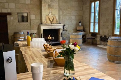 Château entouré d'arbres, table élégamment dressée, bouteille de champagne et espace de travail avec ordinateur.