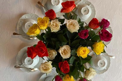 Château entouré d'arbres, table élégamment dressée, bouteille de champagne et espace de travail avec ordinateur.