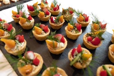 Plateaux de bouchées apéritives avec fromage, raisin, jambon et brochettes, accompagnés de verres de champagne en arrière…