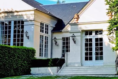 Miniature Location salle Longnes (Yvelines) - Domaine des Clos Vallées #27 Couronne de fleurs blanches et roses suspendue à un arbre sous la lumière du soleil dans un jardin verdoyant.