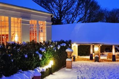 Miniature Location salle Longnes (Yvelines) - Domaine des Clos Vallées #30 Couronne de fleurs blanches et roses suspendue à un arbre sous la lumière du soleil dans un jardin verdoyant.