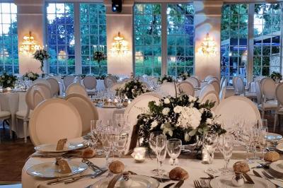 Miniature Location salle Longnes (Yvelines) - Domaine des Clos Vallées #10 Couronne de fleurs blanches et roses suspendue à un arbre sous la lumière du soleil dans un jardin verdoyant.