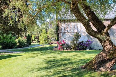 Miniature Location salle Longnes (Yvelines) - Domaine des Clos Vallées #16 Couronne de fleurs blanches et roses suspendue à un arbre sous la lumière du soleil dans un jardin verdoyant.