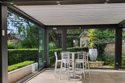 Miniature Location salle Longnes (Yvelines) - Domaine des Clos Vallées #19 Couronne de fleurs blanches et roses suspendue à un arbre sous la lumière du soleil dans un jardin verdoyant.