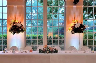 Miniature Location salle Longnes (Yvelines) - Domaine des Clos Vallées #21 Couronne de fleurs blanches et roses suspendue à un arbre sous la lumière du soleil dans un jardin verdoyant.