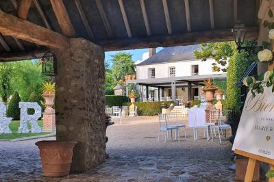 Miniature Location salle Longnes (Yvelines) - Domaine des Clos Vallées #31 Couronne de fleurs blanches et roses suspendue à un arbre sous la lumière du soleil dans un jardin verdoyant.