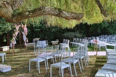 Miniature Location salle Longnes (Yvelines) - Domaine des Clos Vallées #25 Couronne de fleurs blanches et roses suspendue à un arbre sous la lumière du soleil dans un jardin verdoyant.