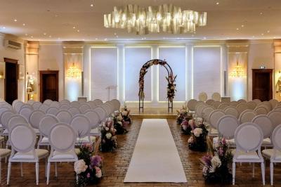 Miniature Location salle Longnes (Yvelines) - Domaine des Clos Vallées #37 Couronne de fleurs blanches et roses suspendue à un arbre sous la lumière du soleil dans un jardin verdoyant.