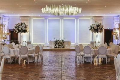 Miniature Location salle Longnes (Yvelines) - Domaine des Clos Vallées #12 Couronne de fleurs blanches et roses suspendue à un arbre sous la lumière du soleil dans un jardin verdoyant.