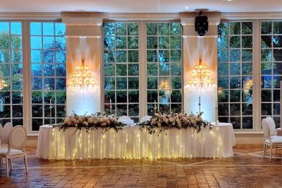 Miniature Location salle Longnes (Yvelines) - Domaine des Clos Vallées #39 Couronne de fleurs blanches et roses suspendue à un arbre sous la lumière du soleil dans un jardin verdoyant.