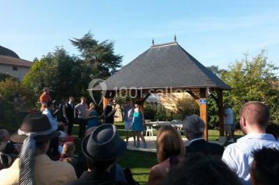Stand décoratif avec des bonbons dans un parc, entouré d'arbres, de personnes assises et d'enfants jouant.