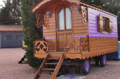 Stand décoratif avec des bonbons dans un parc, entouré d'arbres, de personnes assises et d'enfants jouant.