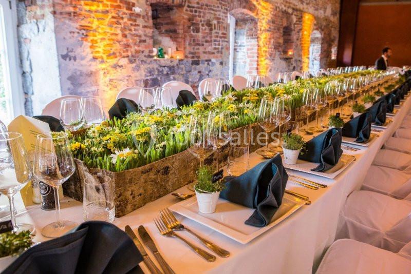 Location salle Anhée (Namur) - Ferme de l'Abbaye de Moulins #5 Table de banquet élégamment dressée avec des nappes blanches, des verres, des serviettes noires et une décoration florale…