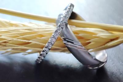 Main portant deux bagues argentées ornées de petits strass, posée sur une surface claire.