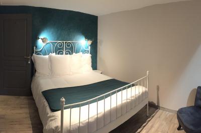 Salle de réception rustique avec poutres en bois apparentes, tables rondes dressées et chaises rouges.