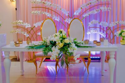 Rouleau croustillant servi sur un lit de légumes colorés avec une garniture florale sur une assiette blanche.