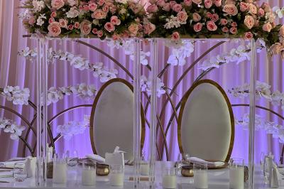 Rouleau croustillant servi sur un lit de légumes colorés avec une garniture florale sur une assiette blanche.