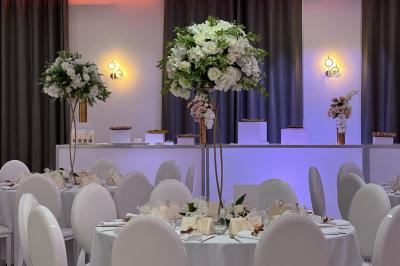 Rouleau croustillant servi sur un lit de légumes colorés avec une garniture florale sur une assiette blanche.