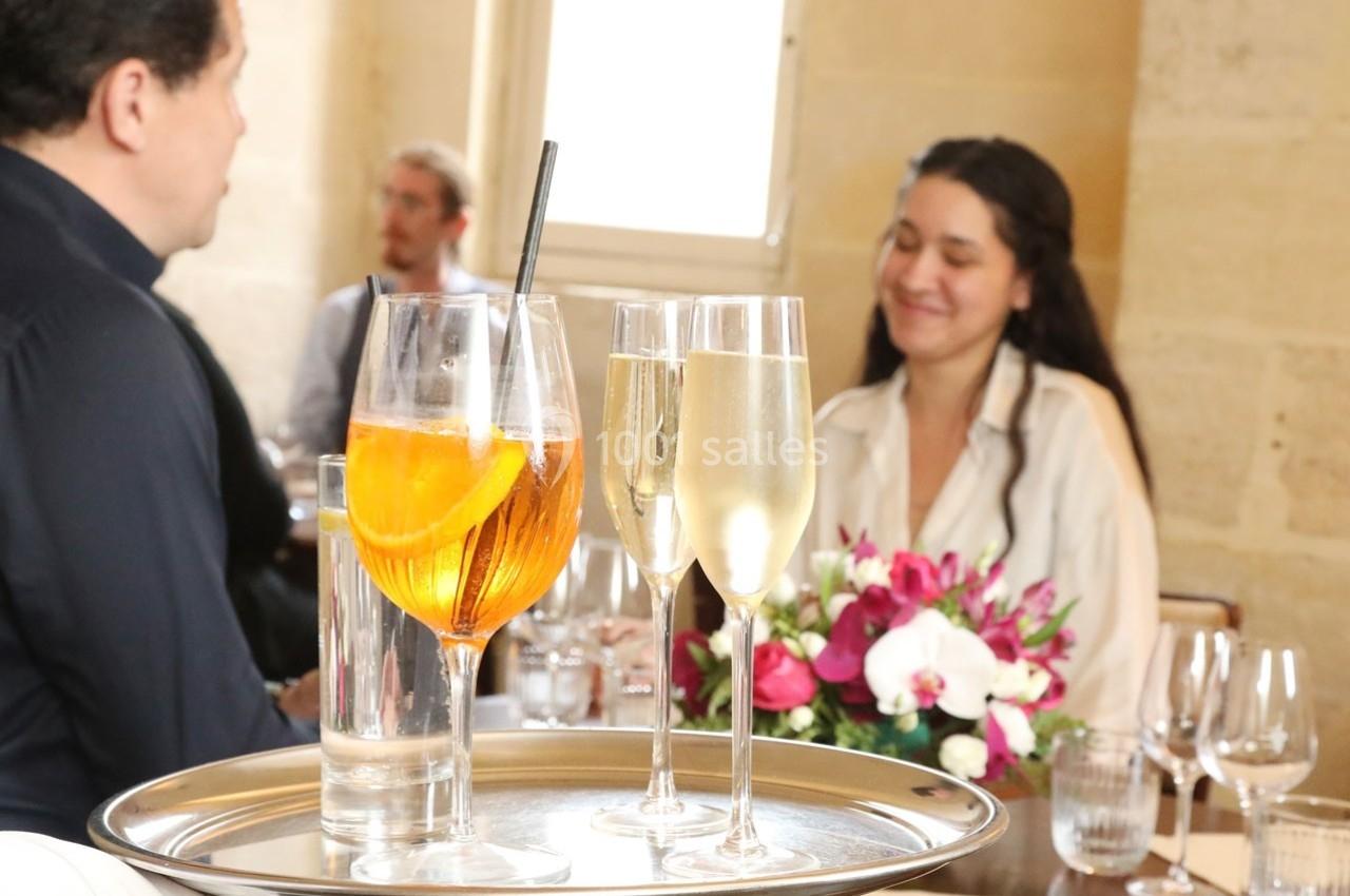 Location salle Chantilly (Oise) - La Capitainerie du Château de Chantilly #23 Un plateau avec un cocktail et deux verres de champagne est servi dans un restaurant élégant.