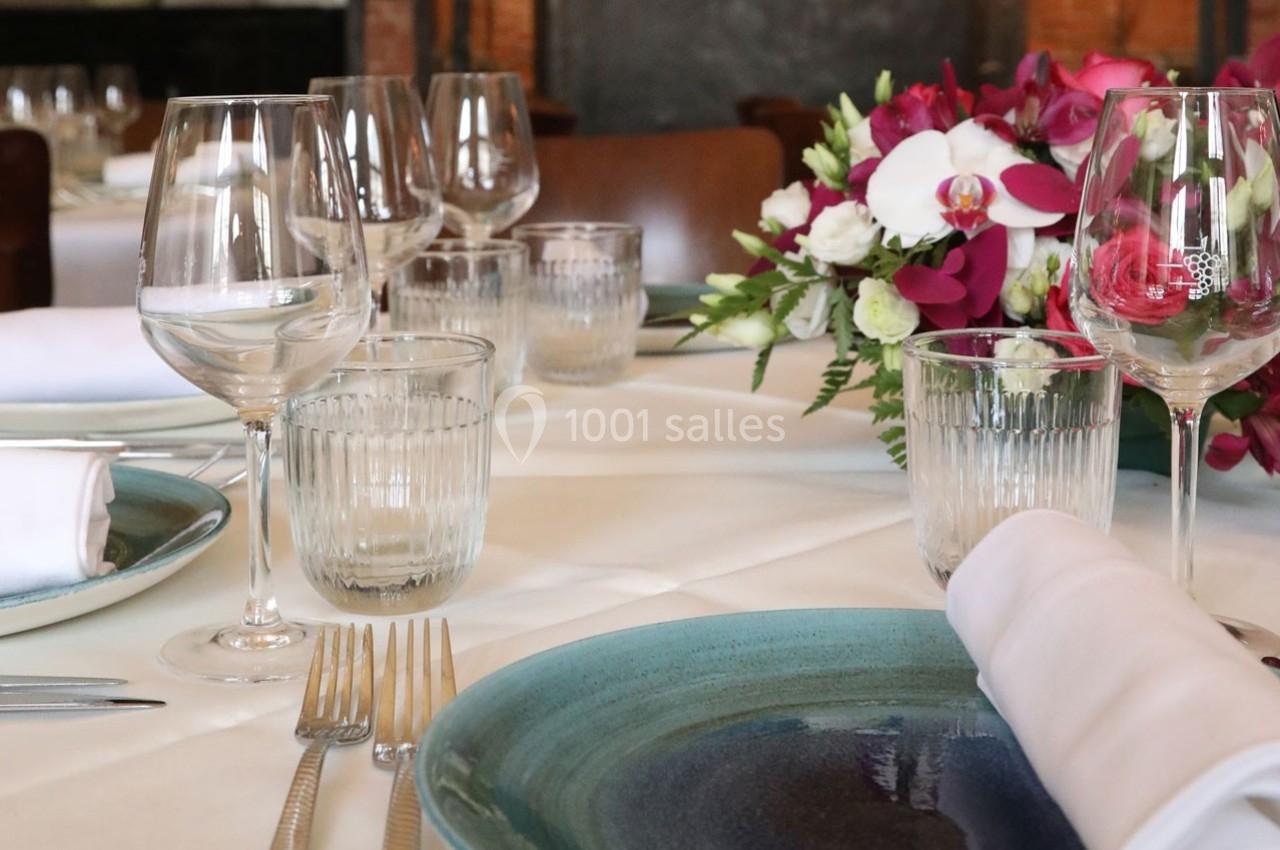 Location salle Chantilly (Oise) - La Capitainerie du Château de Chantilly #27 Table élégamment dressée avec assiettes, verres, couverts et centre de table floral dans un décor chaleureux.