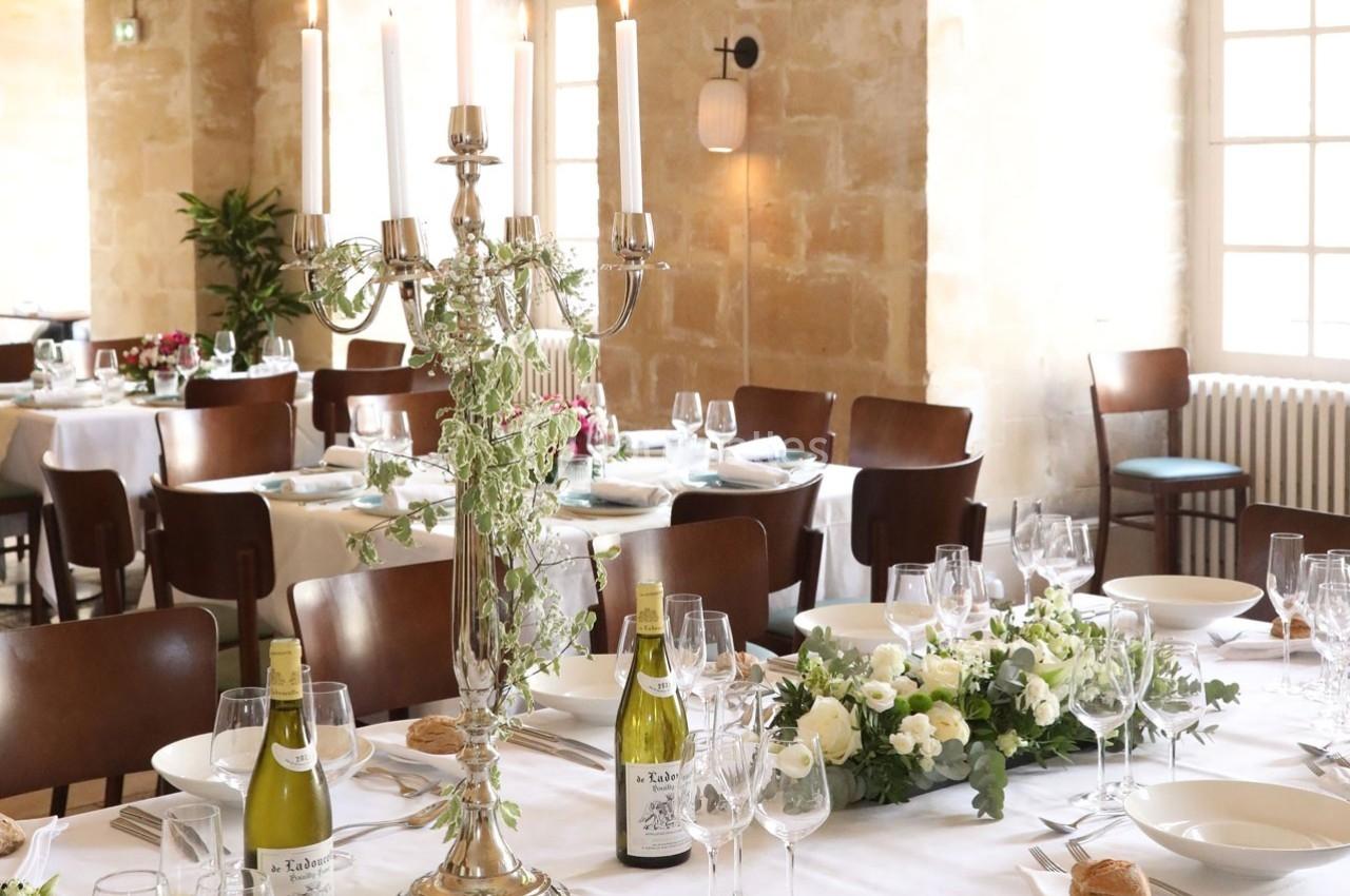 Location salle Chantilly (Oise) - La Capitainerie du Château de Chantilly #13 Salle de réception élégante avec tables dressées, chandeliers, fleurs blanches et bouteilles de vin.