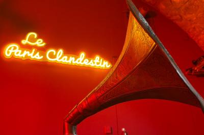 Comptoir lumineux dans une pièce voûtée en pierre, décoré de plantes, lampes et guirlandes lumineuses.