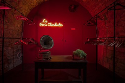 Comptoir lumineux dans une pièce voûtée en pierre, décoré de plantes, lampes et guirlandes lumineuses.