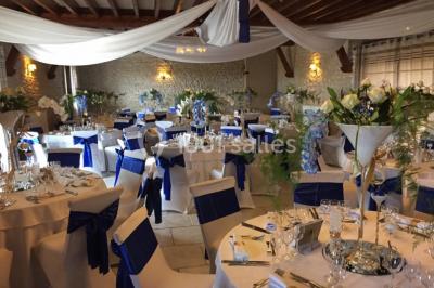 Miniature Location salle Gironville (Seine-et-Marne) - Domaine Saint Pierre #13 Champ de coquelicots rouges au premier plan avec un bâtiment en pierre et des toits en arrière-plan sous un ciel nuageux.