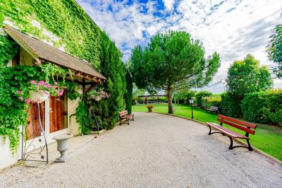 Miniature Location salle Gironville (Seine-et-Marne) - Domaine Saint Pierre #29 Champ de coquelicots rouges au premier plan avec un bâtiment en pierre et des toits en arrière-plan sous un ciel nuageux.