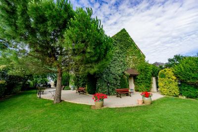 Miniature Location salle Gironville (Seine-et-Marne) - Domaine Saint Pierre #30 Champ de coquelicots rouges au premier plan avec un bâtiment en pierre et des toits en arrière-plan sous un ciel nuageux.
