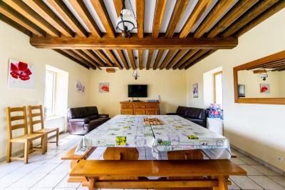 Miniature Location salle Gironville (Seine-et-Marne) - Domaine Saint Pierre #31 Champ de coquelicots rouges au premier plan avec un bâtiment en pierre et des toits en arrière-plan sous un ciel nuageux.