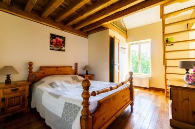 Miniature Location salle Gironville (Seine-et-Marne) - Domaine Saint Pierre #35 Champ de coquelicots rouges au premier plan avec un bâtiment en pierre et des toits en arrière-plan sous un ciel nuageux.