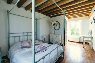 Miniature Location salle Gironville (Seine-et-Marne) - Domaine Saint Pierre #36 Champ de coquelicots rouges au premier plan avec un bâtiment en pierre et des toits en arrière-plan sous un ciel nuageux.