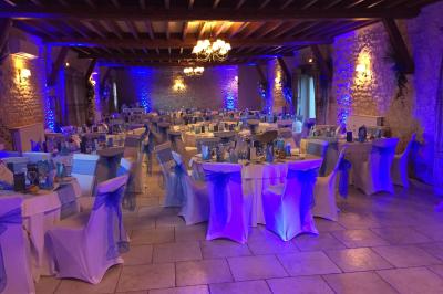 Miniature Location salle Gironville (Seine-et-Marne) - Domaine Saint Pierre #15 Champ de coquelicots rouges au premier plan avec un bâtiment en pierre et des toits en arrière-plan sous un ciel nuageux.