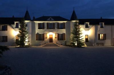 Miniature Location salle Gironville (Seine-et-Marne) - Domaine Saint Pierre #5 Champ de coquelicots rouges au premier plan avec un bâtiment en pierre et des toits en arrière-plan sous un ciel nuageux.