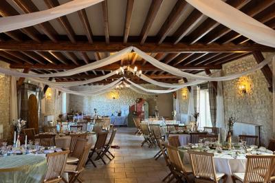 Miniature Location salle Gironville (Seine-et-Marne) - Domaine Saint Pierre #8 Champ de coquelicots rouges au premier plan avec un bâtiment en pierre et des toits en arrière-plan sous un ciel nuageux.