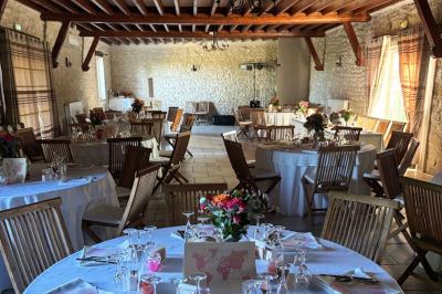 Miniature Location salle Gironville (Seine-et-Marne) - Domaine Saint Pierre #12 Champ de coquelicots rouges au premier plan avec un bâtiment en pierre et des toits en arrière-plan sous un ciel nuageux.