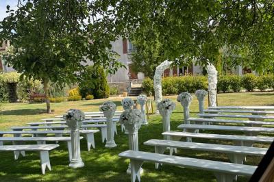 Miniature Location salle Gironville (Seine-et-Marne) - Domaine Saint Pierre #24 Champ de coquelicots rouges au premier plan avec un bâtiment en pierre et des toits en arrière-plan sous un ciel nuageux.