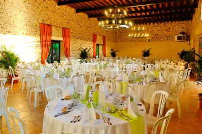 Piscine intérieure avec eau bleue, entourée de plantes en pot et éclairée par des appliques murales.