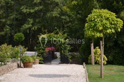 Piscine intérieure avec eau bleue, entourée de plantes en pot et éclairée par des appliques murales.