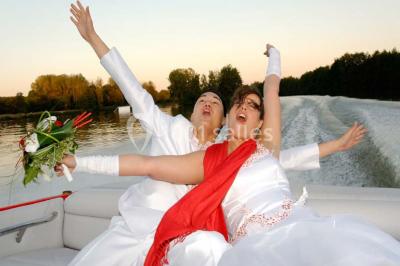 Piscine intérieure avec eau bleue, entourée de plantes en pot et éclairée par des appliques murales.