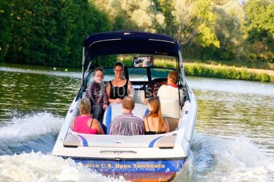 Piscine intérieure avec eau bleue, entourée de plantes en pot et éclairée par des appliques murales.
