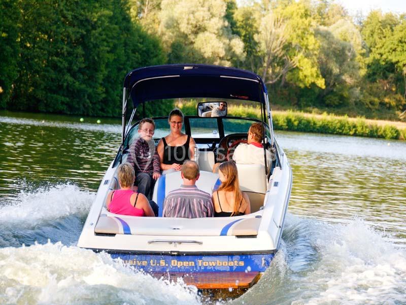 Un groupe de personnes navigue sur un bateau à moteur sur une rivière entourée de végétation.