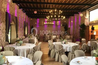 Piscine intérieure avec eau bleue, entourée de plantes en pot et éclairée par des appliques murales.