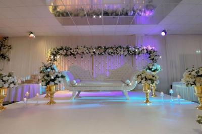 Verres de cocktails colorés garnis de fruits et de feuilles, disposés sur une table lors d'un événement en extérieur.