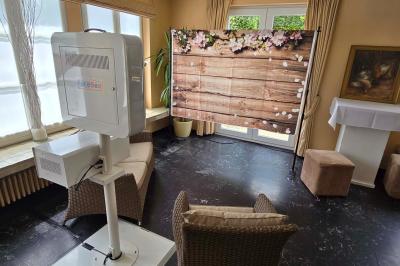 Salle de réception avec tables rondes dressées, nappes blanches, assiettes dorées et décoration florale centrale.