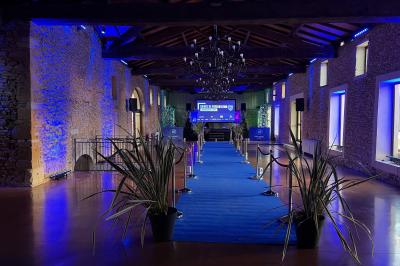 Vue intérieure d'une pièce mansardée lumineuse avec poutres apparentes, sol en bois et une grande fenêtre donnant sur des…